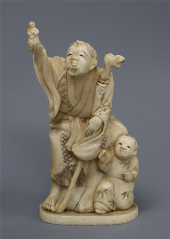 A Japanese Meiji period okimono carving of a figure with a staff, a youth by his side height 13cm